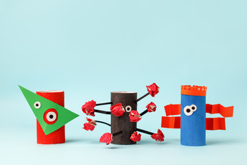 Fototapeta premium Kids art therapy, coronavirus pandemic. Halloween crafts, paper monsters on blue paper background with copy space for text. Concept handcraft, diy, creative idea from toilet tube, recycle