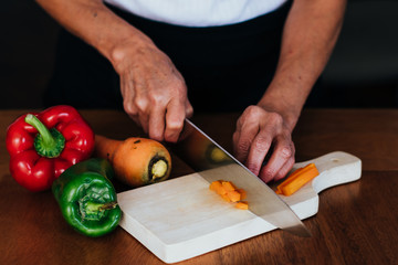 woman cutting vegetables on kitchen board