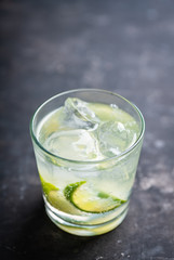 Rum based cocktail caipirinha (variation of cuba libre) on the rustic background. Selective focus. Shallow depth of field.