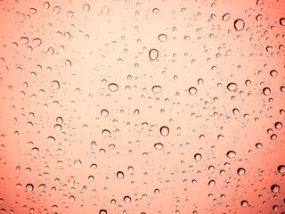 Raindrops on a red glass, abstract red background.