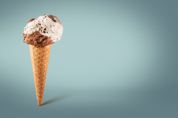 Chocolate and vanilla ice cream cone on colored background