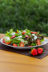 Salad with strawberry and leaves vertical