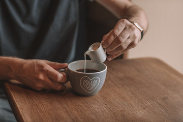 gray cup of coffee and a cup of milk on a wooden table