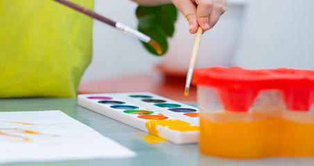 The boy draws with paints . Sit at home. The remote training. Educational classes for children. Article about children's leisure. Home children's classes.