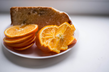Naklejka na ściany i meble Sliced orange on a white plate
