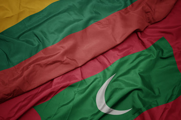 waving colorful flag of maldives and national flag of lithuania.