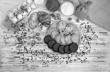 Black and white flat lay of sweets and ingredients for homemade baked goods. Flour, sugar, nuts, milk.