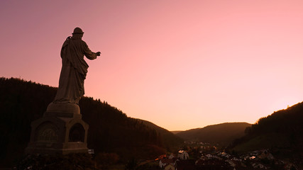 Statue Guter Hirte im Abendrot über Tal