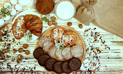 Scene with an assortment of pastries, original Nuremberg gingerbread cookies, rolls, croissants with ingredients. Top view over a wooden textured white background.Coffee shop advertising concept