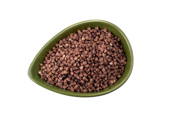 Dry buckwheat in green ceramic bowl isolated on white.