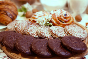 Scene with an assortment of baking, original Nuremberg gingerbread cookies, muffins, croissants with ingredients on a wooden textured white background. Coffee shop advertising concept