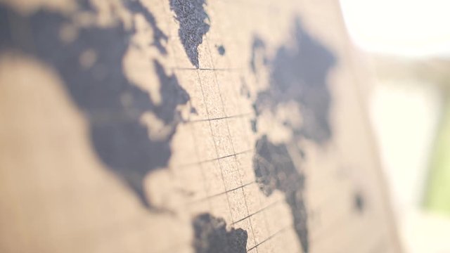An extreme close up of a brown and black coark board world map with a high depth of field.