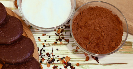 Scene with original Nuremberg gingerbread cookies and ingredients on a wooden textured white background.Cocoa,sugar,milk. Top view. Ingredients for a healthy breakfast. Coffee shop advertising concept