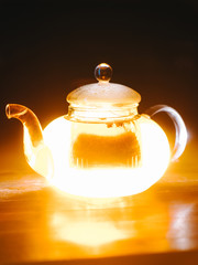 Transparent glass teapot with yellow glow inside