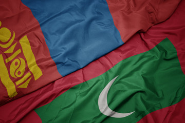waving colorful flag of maldives and national flag of mongolia.