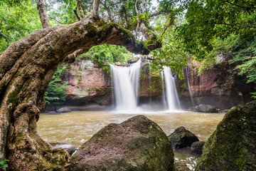 Fototapeta na wymiar Waterfall on mountain cliff with tree curve shape foreground in the tropical rain forest. Beautiful nature waterfall in Khao Yai national park, Nakhonratchasima , Thailand , Haew Suwat waterfall