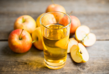 Apple juice with freshly harvested apples on the rustic background. Selective focus. Shallow depth of field.