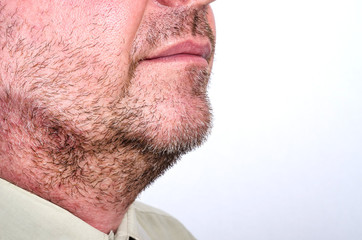 Fototapeta premium Close-up face of an unshaven adult man with bristles with gray hair. Isolate on a white background.