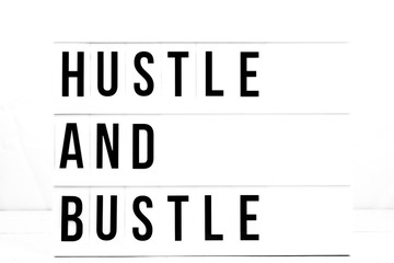 Motivational Hustle and Bustle quote on vintage retro board. Concept. flat lay
