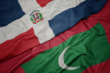 waving colorful flag of maldives and national flag of dominican republic.