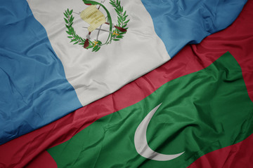 waving colorful flag of maldives and national flag of guatemala.