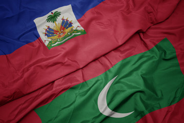 waving colorful flag of maldives and national flag of haiti.