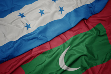 waving colorful flag of maldives and national flag of honduras.