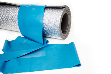 Training rubber and yoga mat on a white background