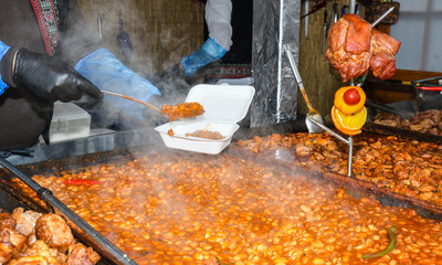 Beans stew, chili sin carne, large pot on fire cooking during food festival.