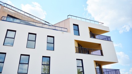 Contemporary residential building exterior in the daylight. Modern apartment buildings on a sunny day with a blue sky. Facade of a modern apartment building