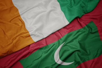 waving colorful flag of maldives and national flag of cote divoire.