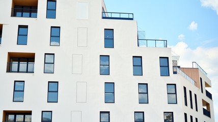 Contemporary residential building exterior in the daylight. Modern apartment buildings on a sunny day with a blue sky. Facade of a modern apartment building