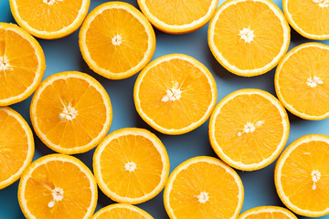 Pattern of oranges on a blue background. Top view.