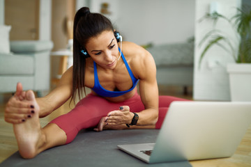 Obraz premium Young athletic woman making a vlog about stretching exercises at home.