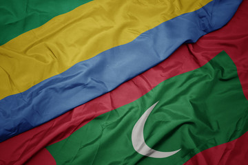 waving colorful flag of maldives and national flag of gabon.