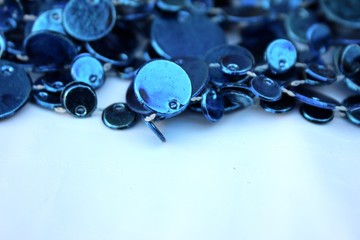 Blue shiny decoration on a white background. Christmas blue beads isolated on white with place for text. Close-up new year background with Christmas balls toned trendy classic blue color. holiday