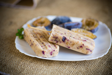 plum sweet homemade ice cream on a stick with slices of plum inside, in a plate