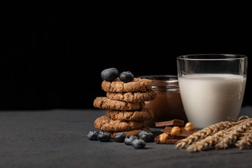 American breakfast still life. Oatmeal cookies, glass of milk, chocolate paste top view.