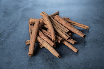 Cinnamon sticks on concrete, stone background.