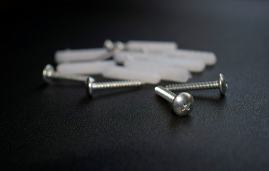 Dowels are randomly laid out on a black surface.