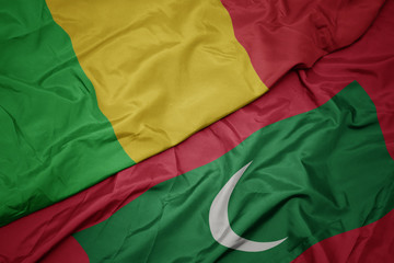 waving colorful flag of maldives and national flag of mali.