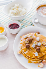 A breakfast with panckakes latte and rice porrige