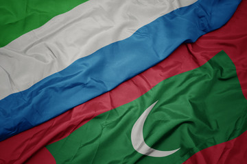 waving colorful flag of maldives and national flag of sierra leone.