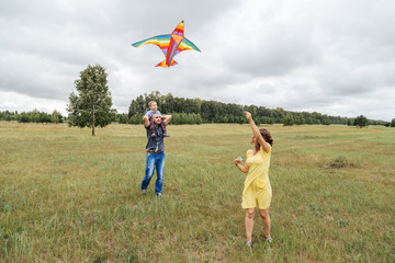 A family flies a kite on the field.