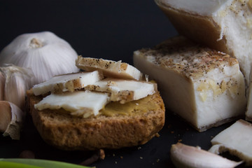 Bread with salted bacon and onions. Garlic on the table. Lunch, dinner. Meal.