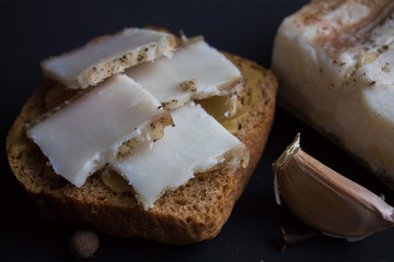 Bread with salted bacon and onions. Garlic on the table. Lunch, dinner. Meal.