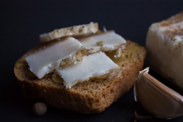 Bread with salted bacon and onions. Garlic on the table. Lunch, dinner. Meal.