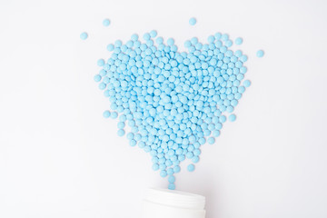 Heaps of blue pills on white background