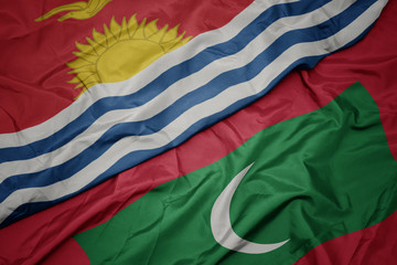 waving colorful flag of maldives and national flag of Kiribati .