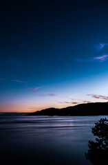 Naklejka na ściany i meble Sunset over the ocean with stars 